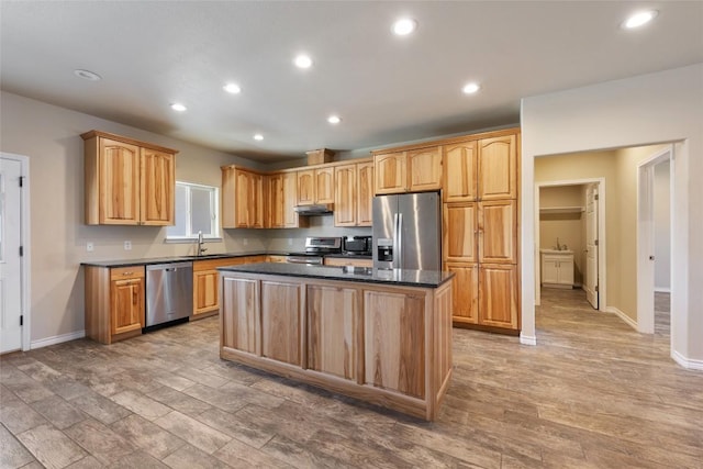 kitchen featuring a center island, recessed lighting, appliances with stainless steel finishes, light wood-style floors, and a sink