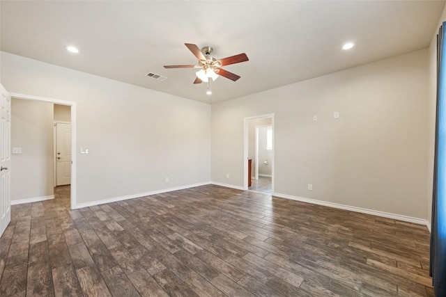 spare room with baseboards, visible vents, dark wood finished floors, and a ceiling fan