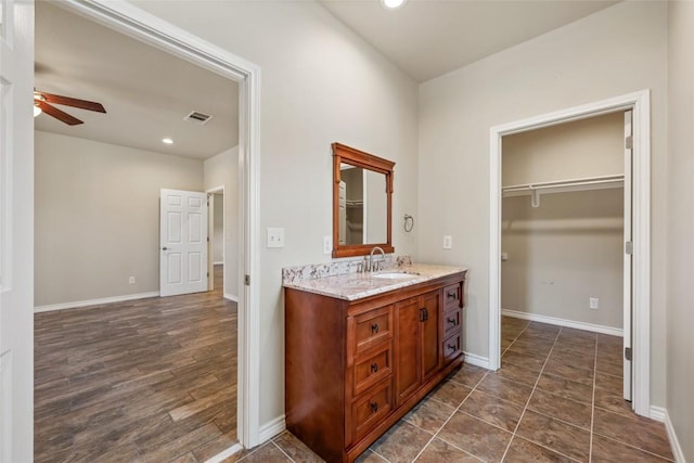 bathroom featuring ceiling fan, vanity, visible vents, and baseboards