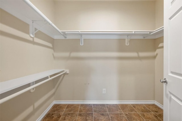 spacious closet with dark tile patterned flooring