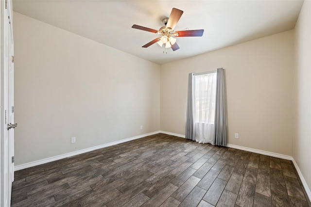 empty room featuring dark wood finished floors, a ceiling fan, and baseboards