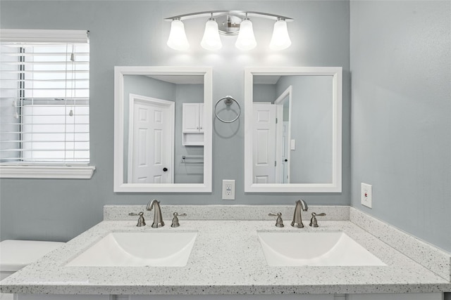 bathroom with double vanity, plenty of natural light, and a sink