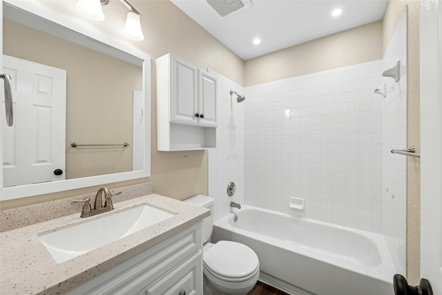 bathroom with visible vents, a textured wall, toilet, shower / bathtub combination, and vanity