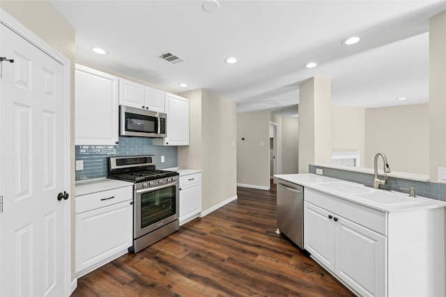 kitchen with dark wood-style floors, light countertops, visible vents, appliances with stainless steel finishes, and a sink