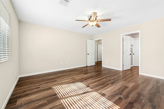 unfurnished bedroom with dark wood-style floors, visible vents, baseboards, and a ceiling fan