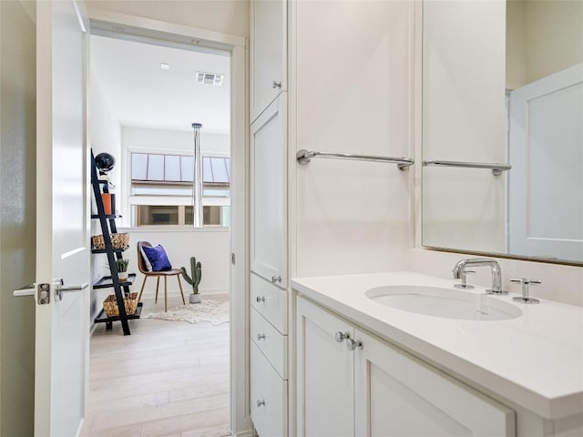 bathroom featuring visible vents, wood finished floors, and vanity