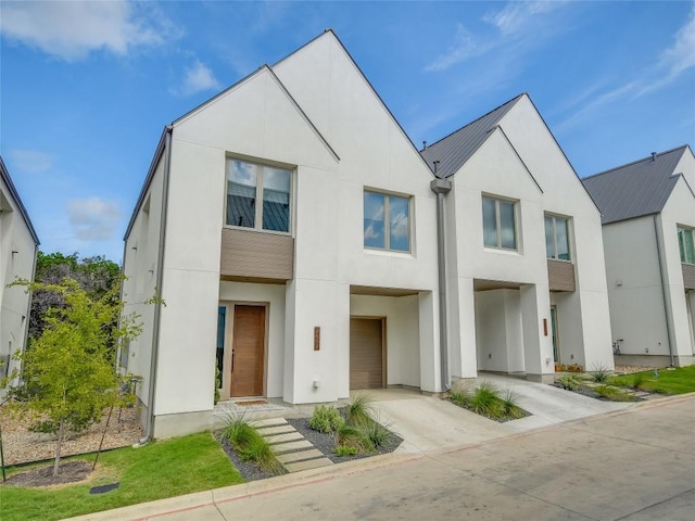 view of front of home featuring concrete driveway and stucco siding