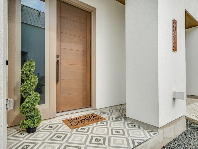 view of exterior entry with stucco siding