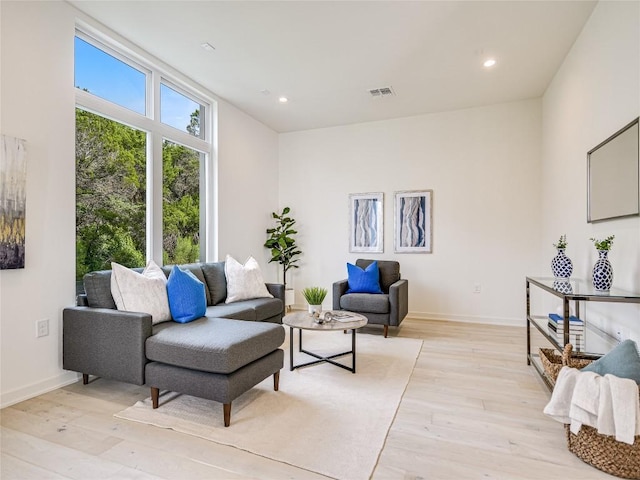 living room with baseboards, light wood finished floors, visible vents, and recessed lighting