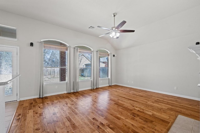 unfurnished living room featuring lofted ceiling, visible vents, hardwood / wood-style floors, ceiling fan, and baseboards