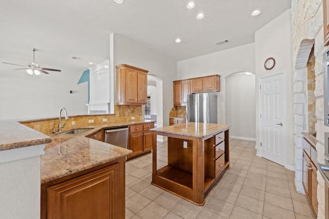 kitchen featuring arched walkways, a sink, visible vents, appliances with stainless steel finishes, and open shelves