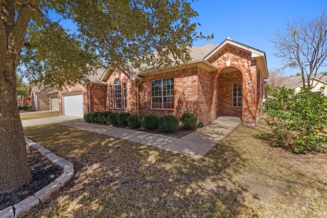 single story home featuring a garage, concrete driveway, and brick siding