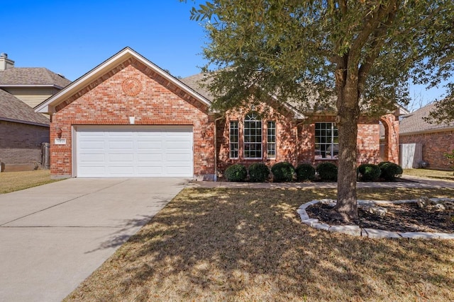 single story home with a garage, concrete driveway, and brick siding