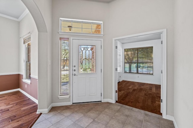 foyer with a wealth of natural light, arched walkways, and wood finished floors