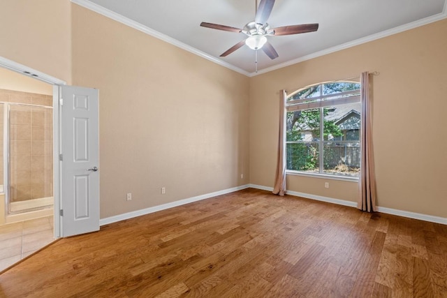 spare room featuring crown molding, baseboards, ceiling fan, and wood finished floors