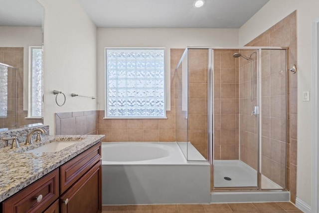 bathroom with a garden tub, a shower stall, tile patterned flooring, and vanity