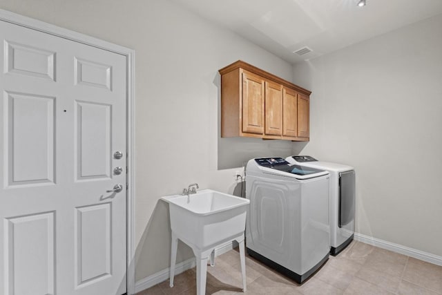 washroom featuring washer and dryer, cabinet space, visible vents, and baseboards