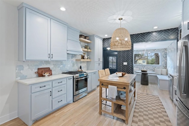 kitchen featuring open shelves, stainless steel appliances, tasteful backsplash, light countertops, and light wood-style floors