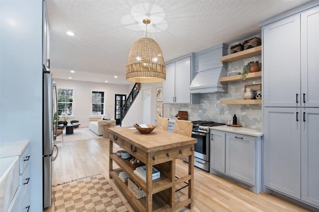 kitchen featuring stainless steel appliances, open shelves, gray cabinets, and light countertops