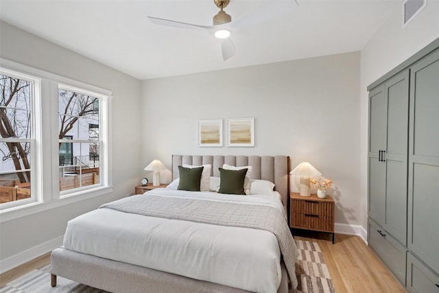 bedroom featuring a ceiling fan, visible vents, baseboards, a closet, and light wood-type flooring