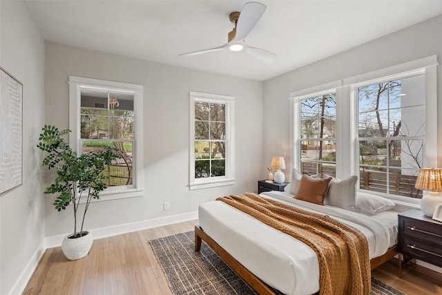 bedroom featuring ceiling fan, wood finished floors, and baseboards