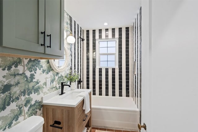 bathroom featuring tub / shower combination, vanity, toilet, and wallpapered walls