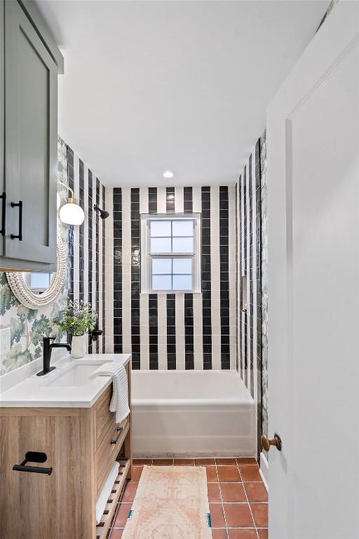 full bath featuring washtub / shower combination, wallpapered walls, vanity, and tile patterned floors