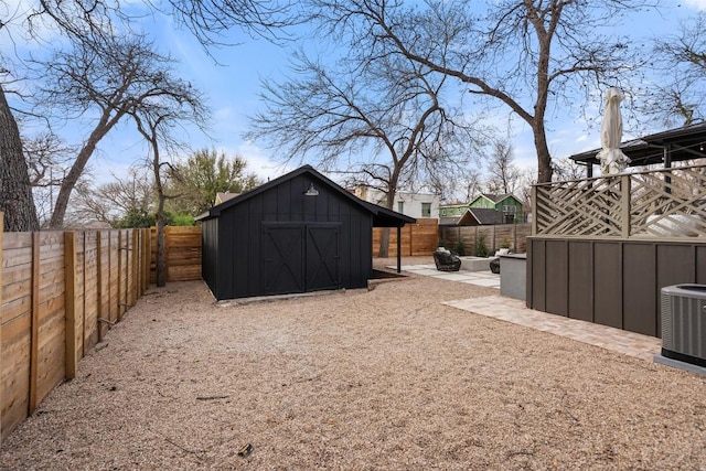 view of yard with a patio, a fenced backyard, a storage unit, an outdoor structure, and central AC