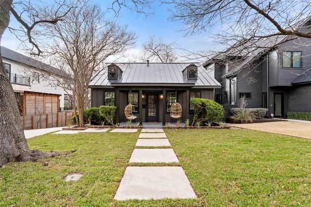 view of front of home featuring metal roof, a standing seam roof, a front yard, and board and batten siding