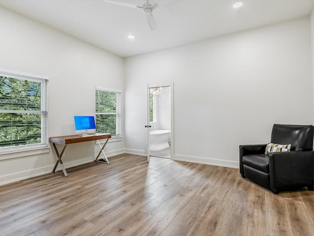 living area featuring a healthy amount of sunlight, light wood-style flooring, baseboards, and ceiling fan