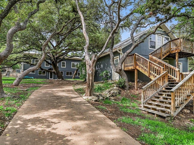 view of front of home featuring concrete driveway, a deck, and stairs