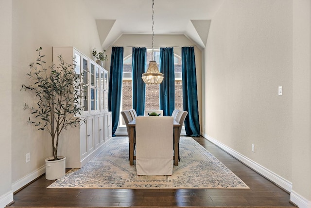 dining space featuring lofted ceiling, an inviting chandelier, baseboards, and hardwood / wood-style floors