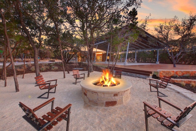 view of property's community featuring an outdoor fire pit and a patio