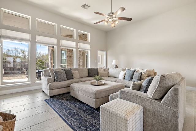 living area with a ceiling fan, visible vents, baseboards, and light tile patterned floors