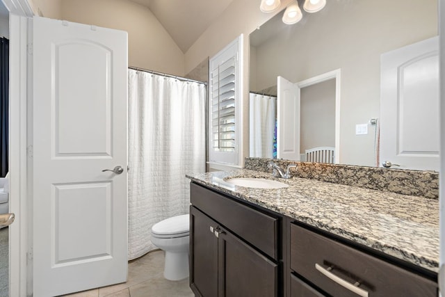 bathroom with lofted ceiling, vanity, toilet, and tile patterned floors