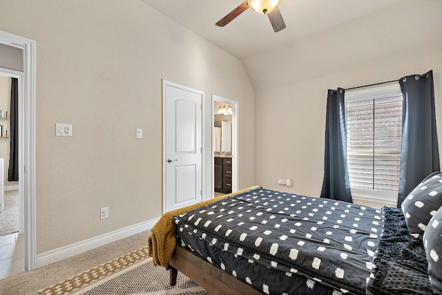 carpeted bedroom featuring connected bathroom, vaulted ceiling, baseboards, and ceiling fan