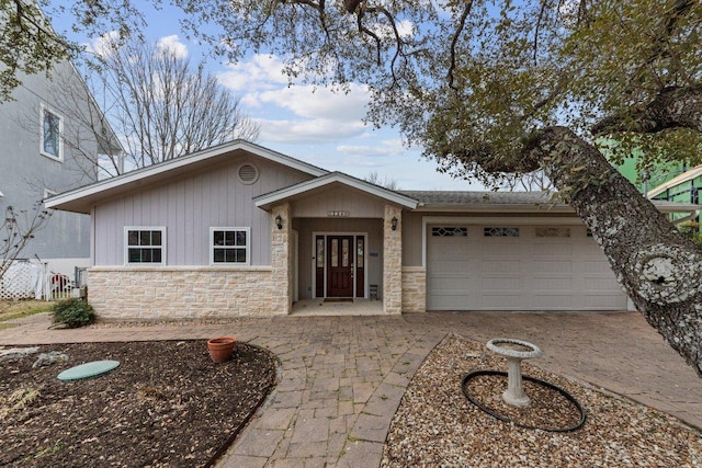 view of front of house with stone siding, driveway, and an attached garage