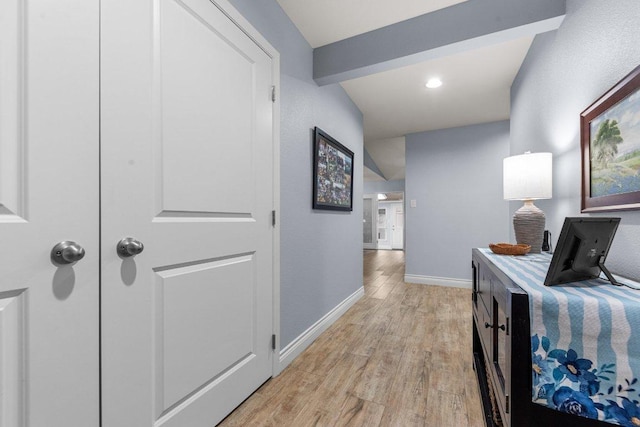 corridor with light wood-style floors and baseboards