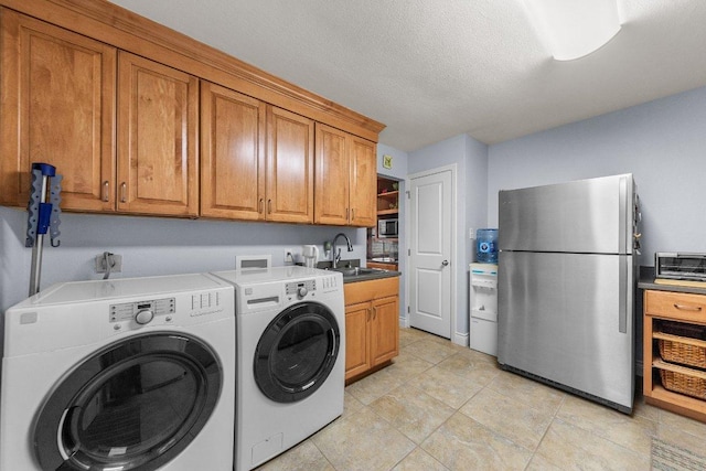 washroom featuring a textured ceiling, a toaster, a sink, and washer and dryer