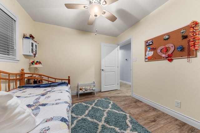 bedroom with wood finished floors, a ceiling fan, and baseboards