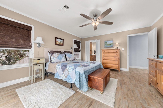 bedroom with light wood finished floors, baseboards, visible vents, a ceiling fan, and crown molding