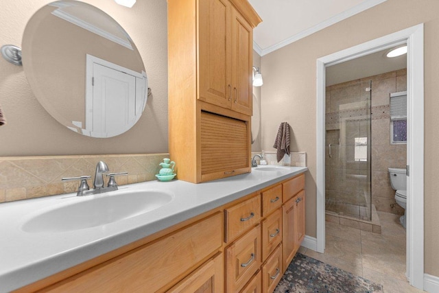 full bathroom with double vanity, a stall shower, toilet, ornamental molding, and a sink