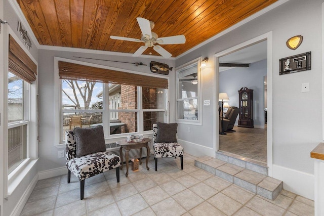 sitting room with wooden ceiling, baseboards, and crown molding