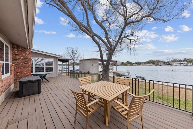 wooden terrace featuring a water view and outdoor dining space