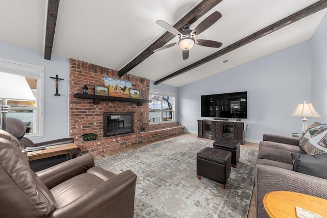 living area with lofted ceiling with beams, a fireplace, a ceiling fan, and baseboards