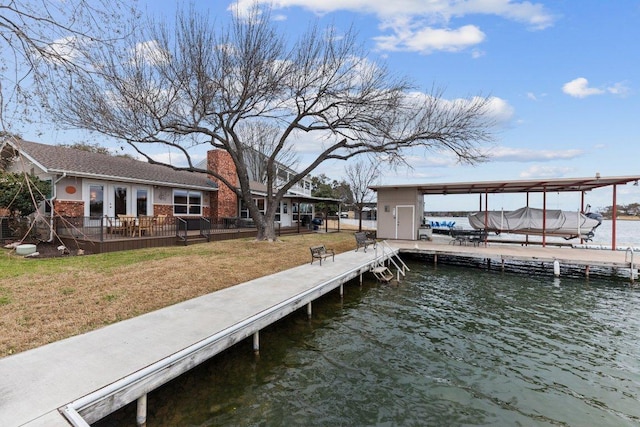 dock area with a water view and a yard