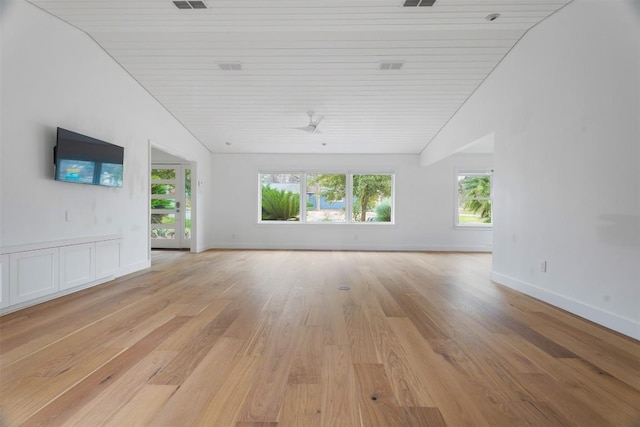 unfurnished living room featuring light wood-type flooring, plenty of natural light, and baseboards