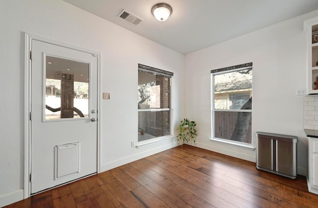 interior space featuring visible vents, dark wood finished floors, and baseboards