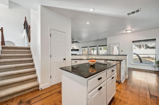 kitchen with a sink, visible vents, stainless steel dishwasher, light wood-type flooring, and a center island