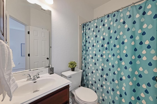 bathroom with a textured wall, curtained shower, toilet, visible vents, and vanity